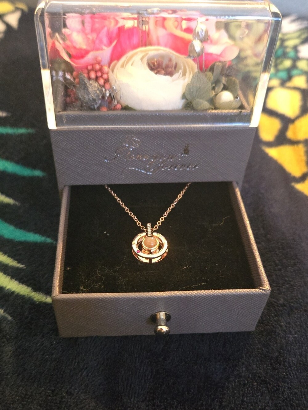 The image shows a grey gift box with preserved flowers